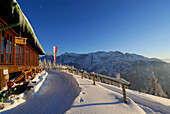 Hut Vorderkaiserfeldenhuette in winter with Tyrolean flag and Wilder Kaiser range, Zahmer Kaiser, Kaiser range, Kufstein, Tyrol, Austria