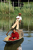 Monk on boat for alms. Inle Lake. Shan State. Myanmar.
