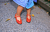 Close up young girl with red shoes on