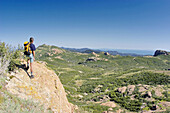 Hiker enjoying the view of Sandstone Peak from the summit of Tri Peaks, Circle X Ranch, Santa Monica Mountains National Recreation Area, California