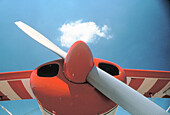 Small plane nose with propeller and cloud