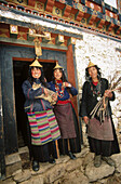 Laya women in doorway. Traditional dress and conical bamboo hats. Laya. Bhutan