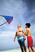 Mature man with grandchild flying a kite