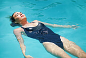 Blond woman floating in the pool