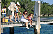 Family fishing on a dock at the beach. Florida. USA
