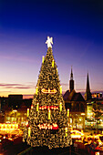 View over Christmas market with giant Christmas tree in the evening, Dortmund,  North Rhine-Westphalia, Germany