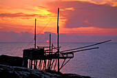 Fischernetz Gestänge im Sonnenaufgang in Trabucco, Punta Lunga bei Vieste, Gargano, Apulien, Italien