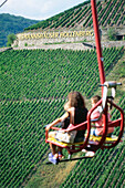 Persons in chair lift passing vineyard, Assmannshausen, Rhine District, Hesse, Germany