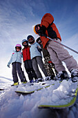 Children wearing ski helmets and ski googles standing side by side, skiing region Sonnenkopf, Vorarlberg, Austria