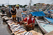 Fisherman selling fish at the harbour and fishing boats outside Mercado Ver O Peso Market, Belem, Para, Brazil, South America