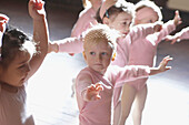 Group of 3 year old girls in ballet class, dressed in pink leotards