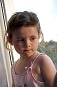headshot of a 4 year old girl sitting looking thoughtful