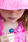 Headshot, 4 year old girl looking at a blue lolly