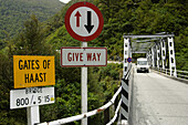 Caravan on one-lane bridge over Gates of Haast, right of way sign, yield . Haast Pass. New Zealand