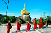 Buddhist monks collecting food. Kyaiktiyo Pagoda (Golden Rock Pagoda) at dusk. Mon State. Myanmar (Burma)