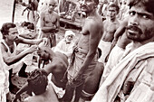 Hindus shaving their heads as a sign of mourning. Benares. India