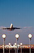 Boeing 747 taking off with runway landing lights in foreground