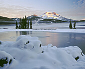 Snow covers Sparks Lake with the sunrise on South Sister. Deschutes National Forest. Oregon. USA