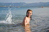 Kleines Mädchen planscht im Wasser am Strand, Kroatien, Europa
