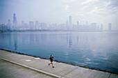 Young man jogging on shore of Lake Michigan, Northerly Island Park, Chicago, Illinois, USA