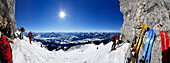 panorama with Kitzbuehel range, Hohe Tauern and Zillertal range and backcountry skiers ascending Herrenstein, Wilder Kaiser range, Kaisergebirge, Tyrol, Austria