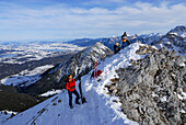 two backcountry skiers on summit of Sebenspitze, Forggensee in background, Tannheim range, Allgaeu range, Allgaeu, Tyrol, Austria