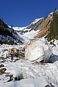 young woman besides giantic lumps from avalanche, Scheidbachtal, Allgaeu range, Allgaeu, Tyrol, Austria