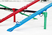 Children playground, seesaw in fresh snow.