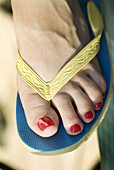 Womans foot and painted toes wearing sandal.