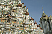 Close up on the tower plated with mosaic of porcelain pieces. Wat Arun temple (Temple of the Dawn). Bangkok. Thailand