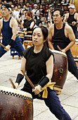 Women and men playing taiko drums during musical performance. Gion Matsuri (festival), Yasaka shrine, Kyoto, Japan.