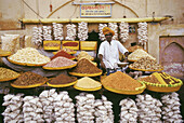 A shopkeeper selling grains and sweets outside the City Palace. Jaipur, Rajasthan, India.