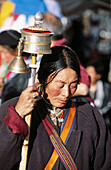Tibetan woman with prayer wheel on Barkhor Street. Lhasa. Tibet.