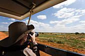 Woman photographying during safari tour, Tsavo East National Park, Coast, Kenya