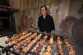Mann, Agis Jacovides, an einem Grill, gegrillte Wachteln am Spieß, The Village Tavern, Pano Platres, Südzypern, zypern