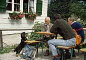 Three men and dog at the Tutzinger Hut, Bavaria, Upper Bavaria, Bavaria, Germany