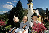 Three children in traditional costume at a church festival, Bavaria, Germany