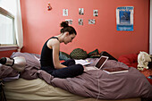 A young woman 20 years old sitting in her room working on university homework