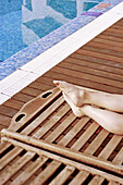 Woman relaxing on long chair near swimming pool at Hotel El Tio Kiko. San José. Cabo de Gata. Andalucia. Spain