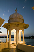 View of the city from the Lake Palace Hotel on Lake Pichola at night. Udaipur. Rajasthan. India