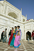 Indian women with colorful saris passing in front of the Taj Mahal. Agra. Uttar Pradesh. India