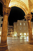 Nightime view from the Rector s Palace pillars and archway framing picture, old town Dubrovnik. Croatia