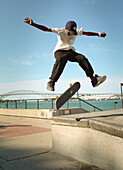 Intermediate school age boy practices skate board skills at a local public park