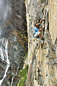 Mann beim Klettern in Maltatal, Wasserfall im Hintergrund, Fallbachfall, Nationalpark Hohe Tauern, Kärnten, Österreich