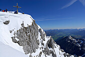 Backcountry skiers resting near summit cross, Pyramidenspitze, Eggersgrinn, Zahmer Kaiser, Kaiser range, Tyrol, Austria