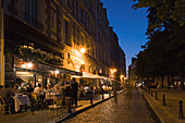 People sitting outside a Bistro in the evening light, Place Dauphine, Isle de la Cité, Paris, France