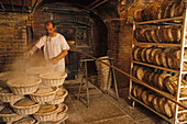 Baker baking bread in the bakery, Boulangerie in Saint Germain des Pres, wood-fired oven, Paris, France