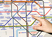 Underground map and man hand. London. England