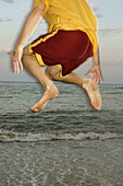 Man jumping on the beach at sunset