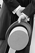 Accessories, Accessory, Adult, Adults, Anonymous, B&W, Back view, Black-and-White, Ceremonies, Ceremony, Contemporary, Daytime, Detail, Details, Dressed up, Elegance, Elegant, Exterior, Hand, Hands, Hat, Hats, Headgear, Hold, Holding, Human, Male, Man, Ma